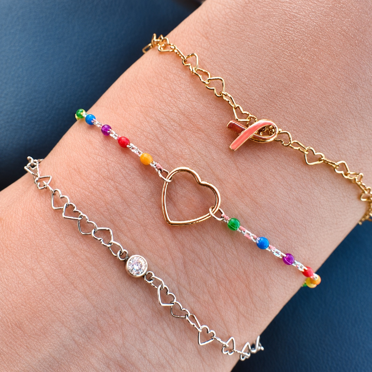 Finished gold and silver bracelets with heart, gemstone, and ribbon details