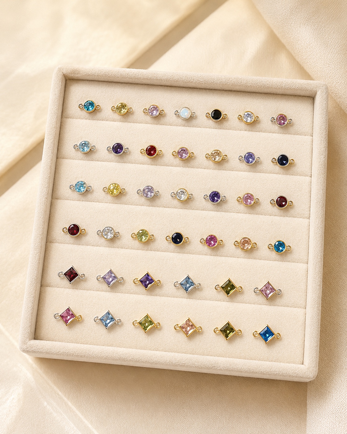 Colorful round and square gemstone connectors on a cream display