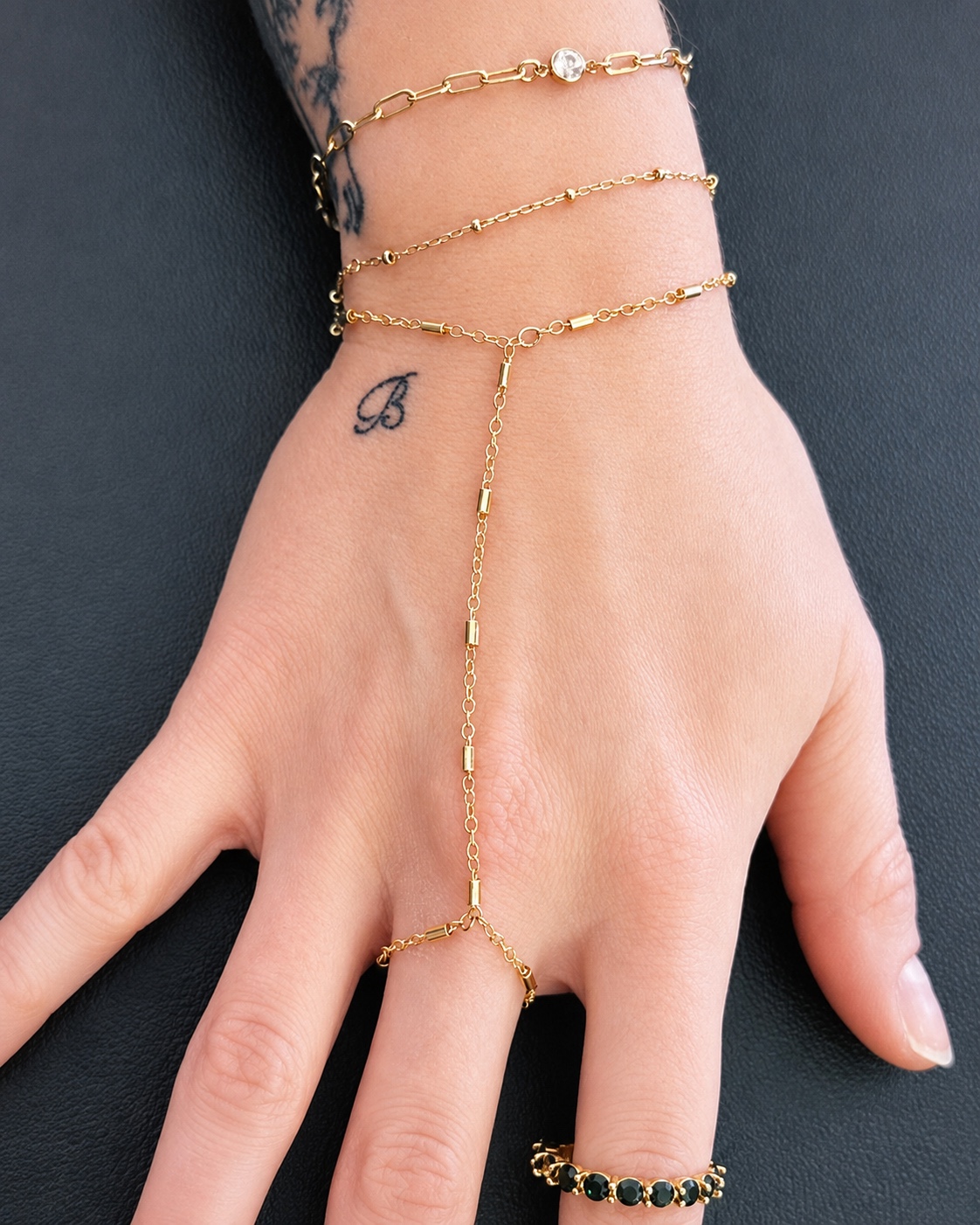 Gold hand chain with a gemstone connector