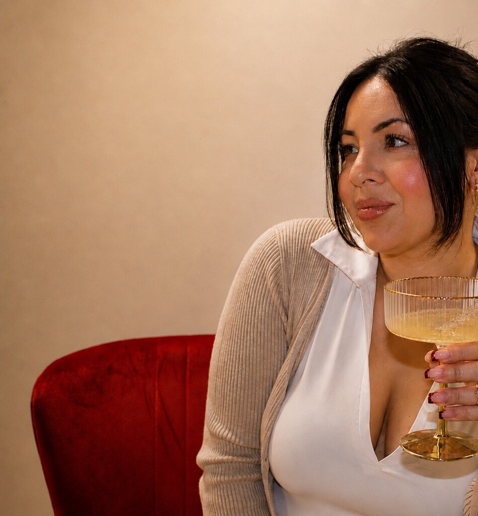 A wider portrait of Jazmin seated in a red chair